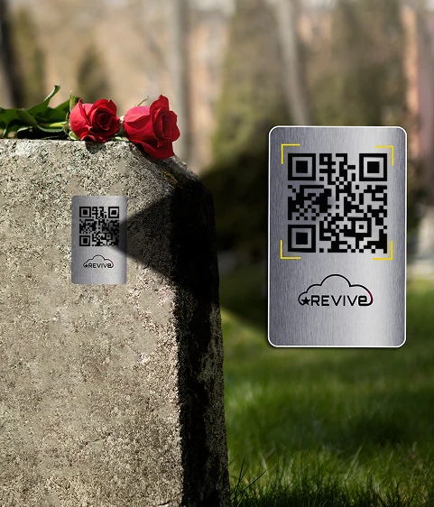 Placa Revive com QR code fixada em uma lápide, com rosas vermelhas ao lado